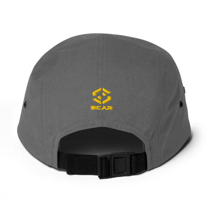 Grey five-panel cap with yellow embroidered logo on front and black adjustable strap