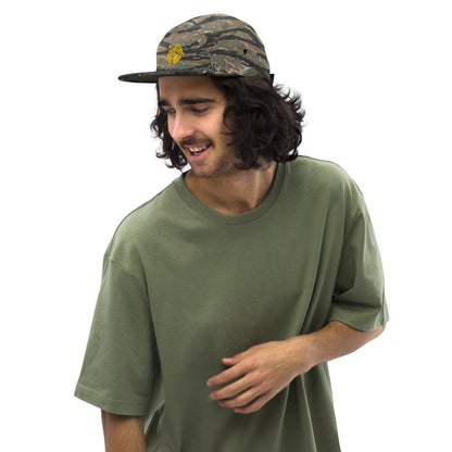 Camo five-panel cap with embroidered yellow emblem and curved brim, worn on head