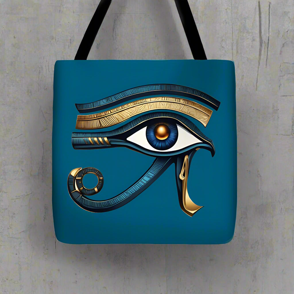 Blue tote bag with Eye of Horus eye and gold crescent charm on front