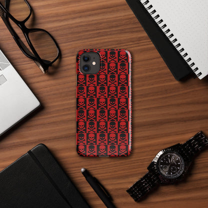 Red and black skull-pattern phone case with camera cutouts on a desk