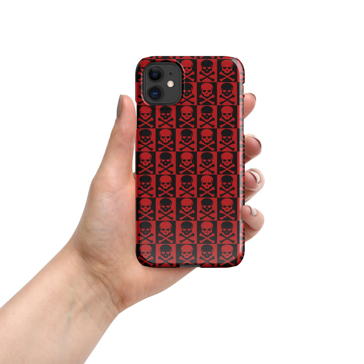 Hand holding red snap phone case with repeating black skull pattern