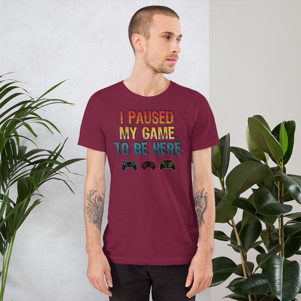 Maroon graphic T-shirt: "I PAUSED MY GAME TO BE HERE" with controller icons