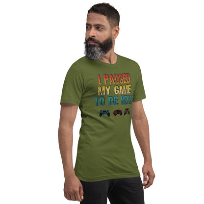 Olive green graphic T-shirt: "I PAUSED MY GAME TO BE HERE" with controller icons