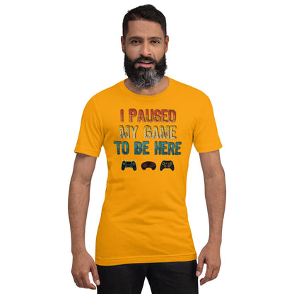 Gold graphic T-shirt: "I PAUSED MY GAME TO BE HERE" with controller icons
