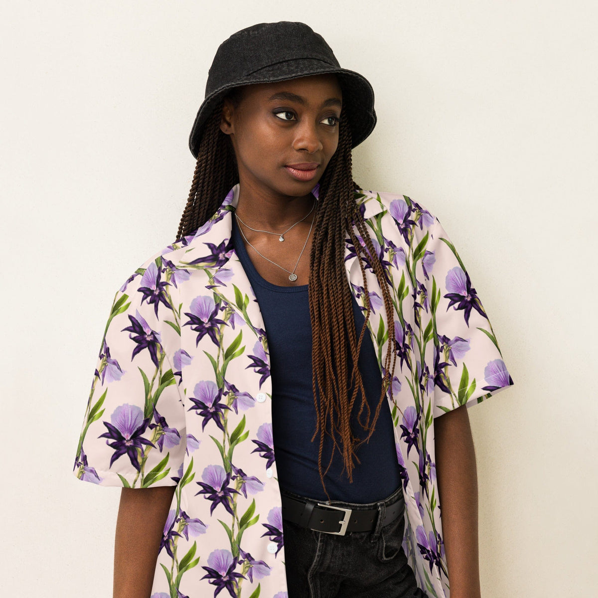 Iris unisex button shirt close-up at shoulders: purple flower print with green stems, short sleeves
