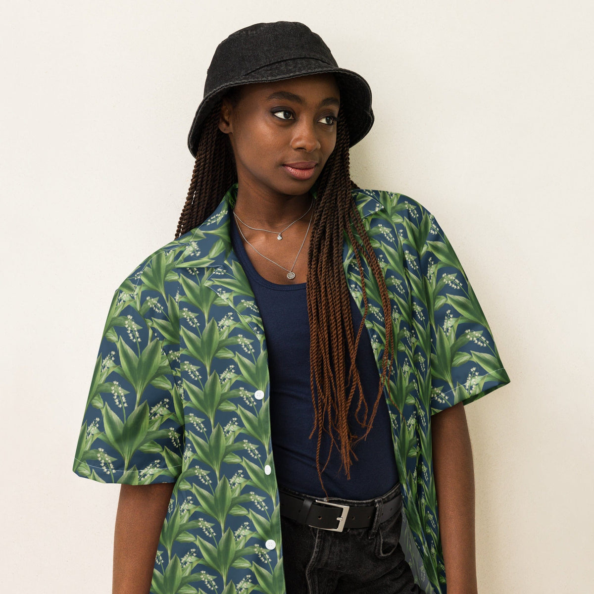 Green leafy print short-sleeve button-up shirt worn with dark jeans.