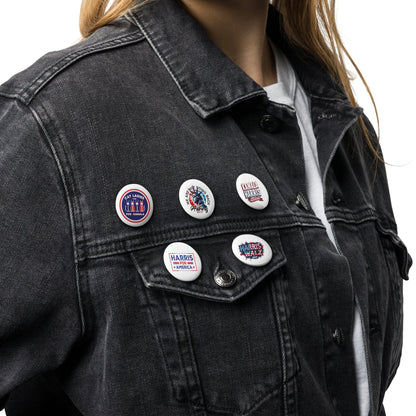 Five round pin buttons on a black denim jacket, front views with campaign graphics