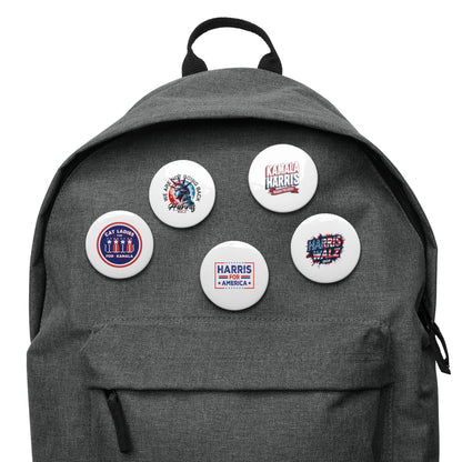 Five round pin buttons attached to the front of a gray backpack