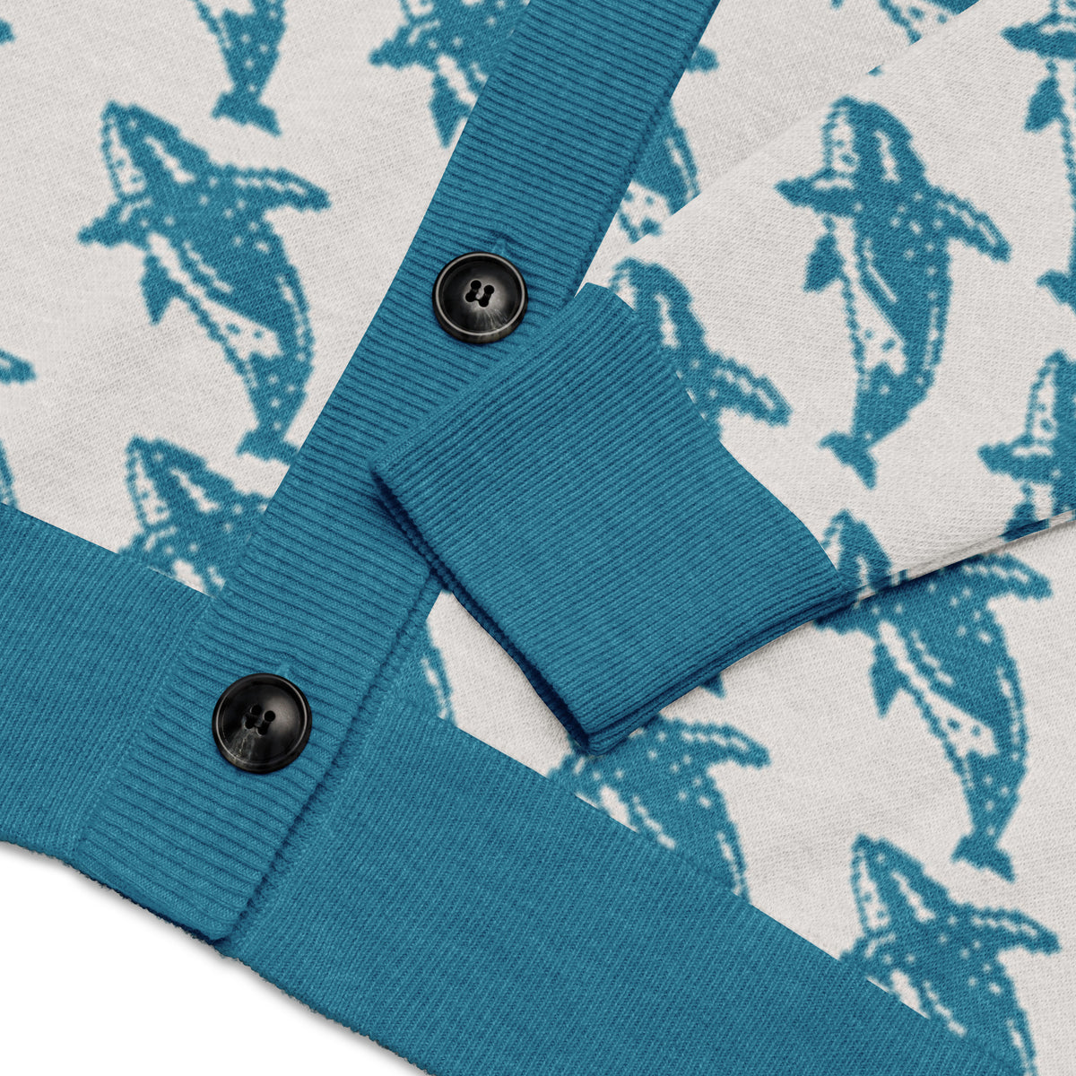 Blue ribbed cuff with dark button detail on knitted cardigan with whale print
