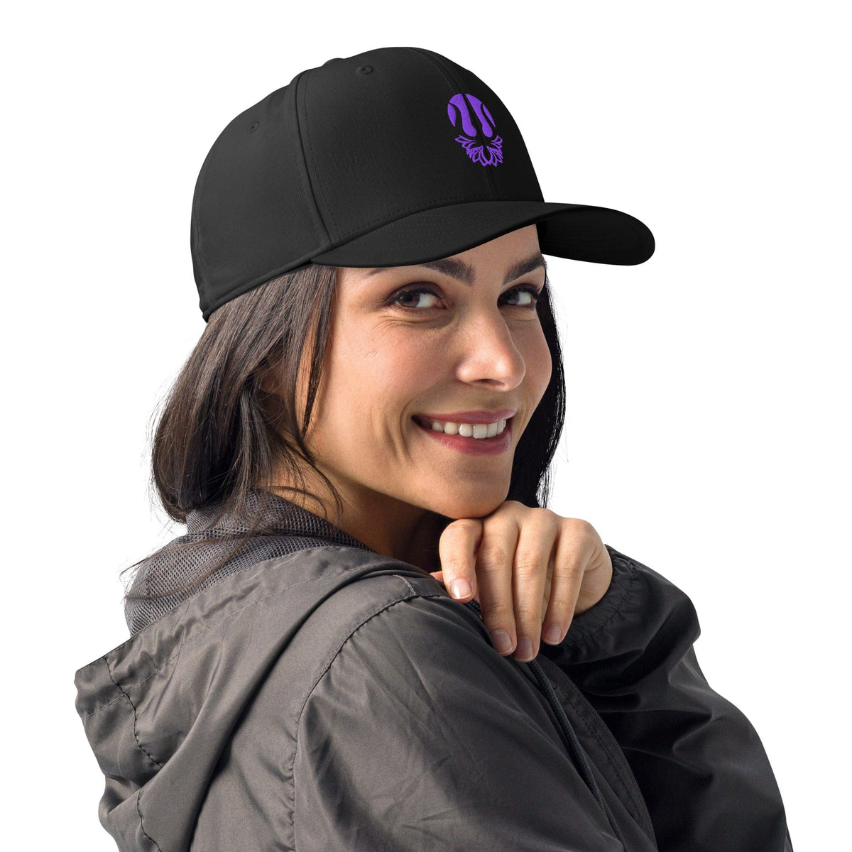 Black embroidered performance cap with purple trident lotus emblem, worn by model