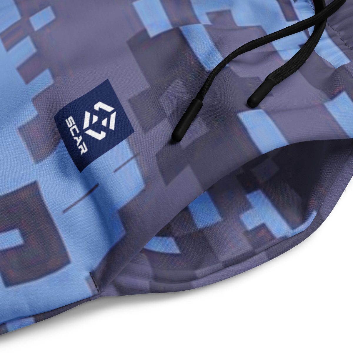 Digital camouflage joggers fabric close-up with printed logo patch and black drawstring cord