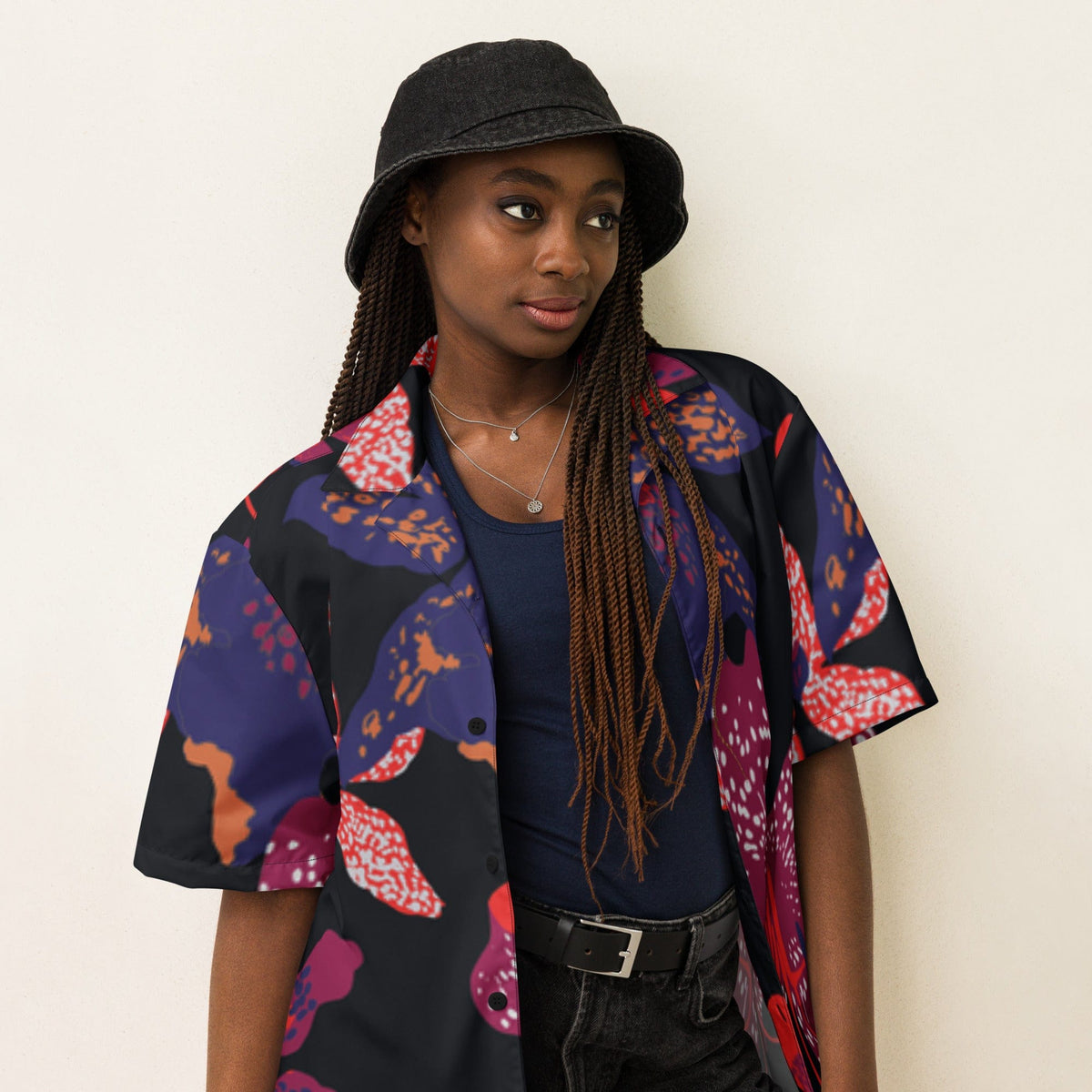 Unisex short-sleeve button-up shirt with dark floral print, close-up on model