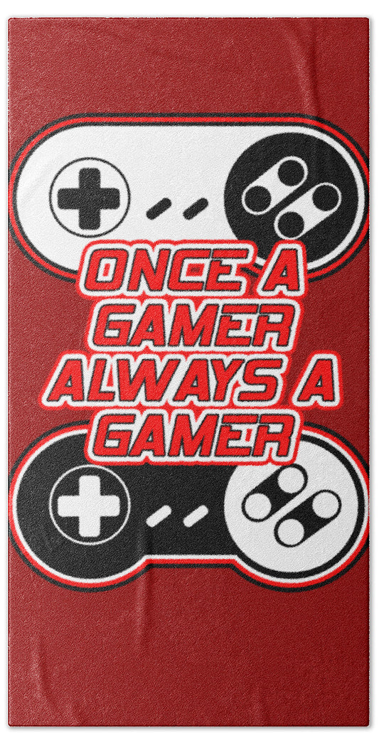 Red beach towel with game controller and joystick icons and 'ONCE A GAMER ALWAYS A GAMER' text