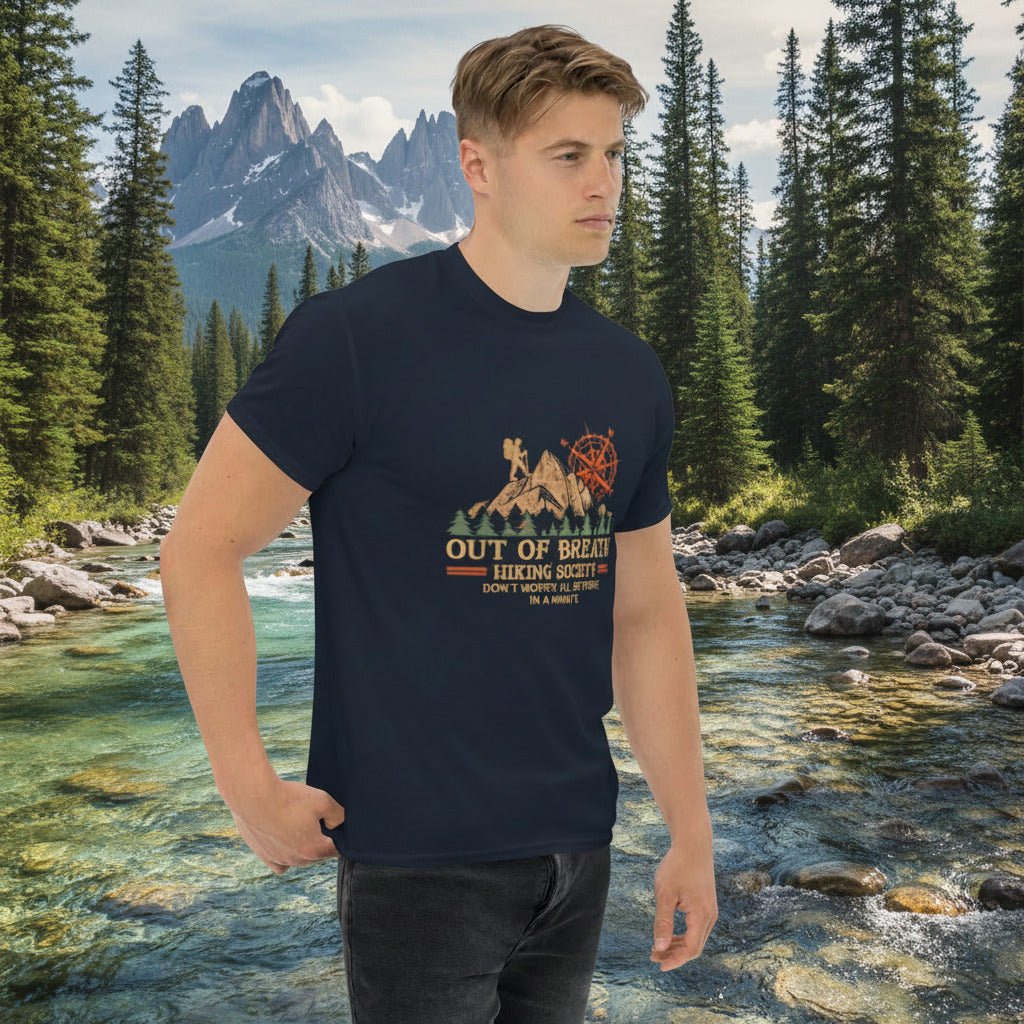 Navy hiking graphic T-shirt with cabin and compass emblem, worn by a man