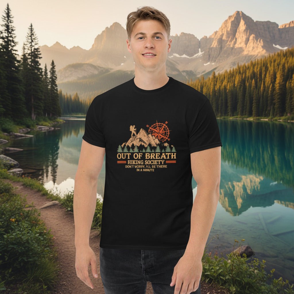 Black hiking graphic T-shirt with cabin and compass emblem, worn by a man