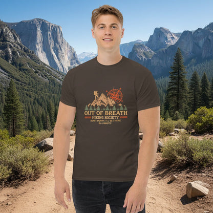 Dark chocolate hiking graphic T-shirt with cabin and compass emblem, worn by a man