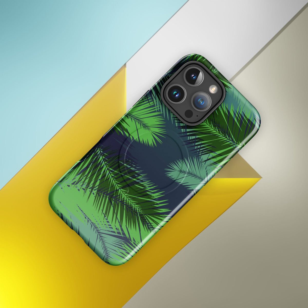 Protective phone case with green palm leaves and dark navy abstract pattern, camera