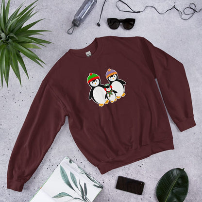 Maroon sweatshirt, laid flat, featuring a penguin family graphic on the chest.