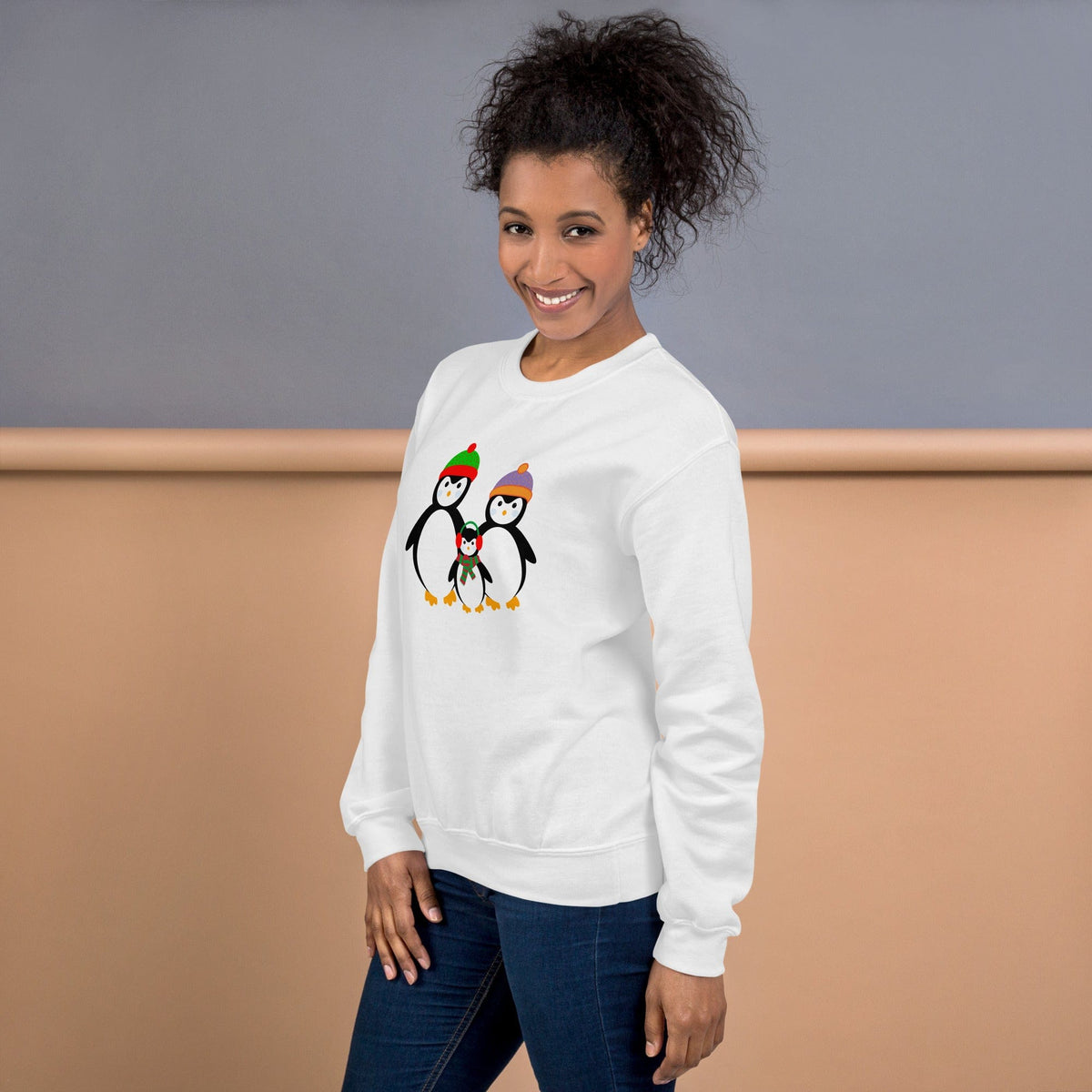 White sweatshirt with small penguin family graphic on chest.