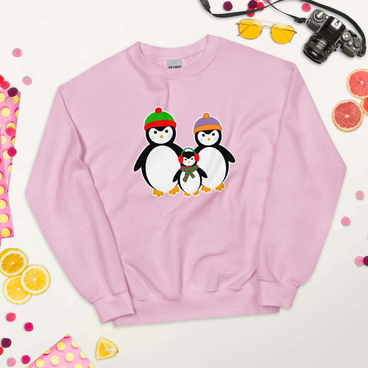 Light pink sweatshirt laid flat with a penguin family graphic on the chest.
