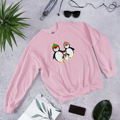 Pink sweatshirt laid flat with a penguin family graphic on the chest.