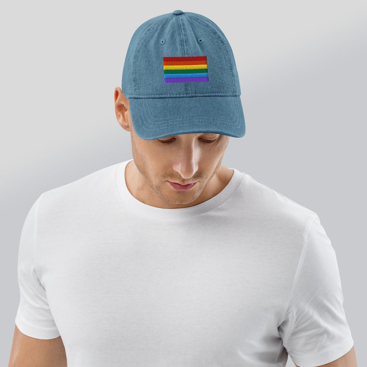 Light blue denim baseball cap with rainbow pride flag patch on front