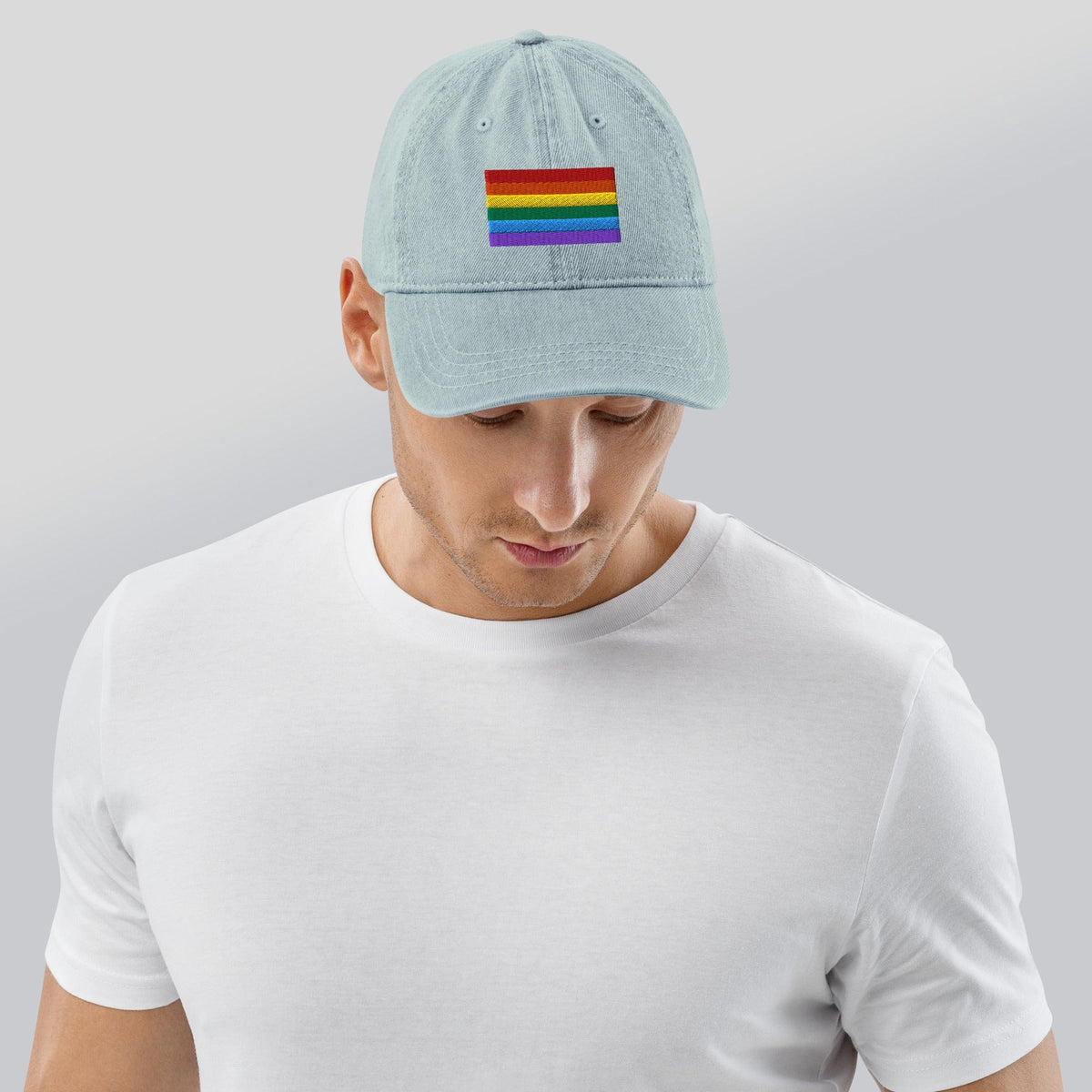 Light blue denim baseball cap with Pride rainbow flag embroidery, viewed from back