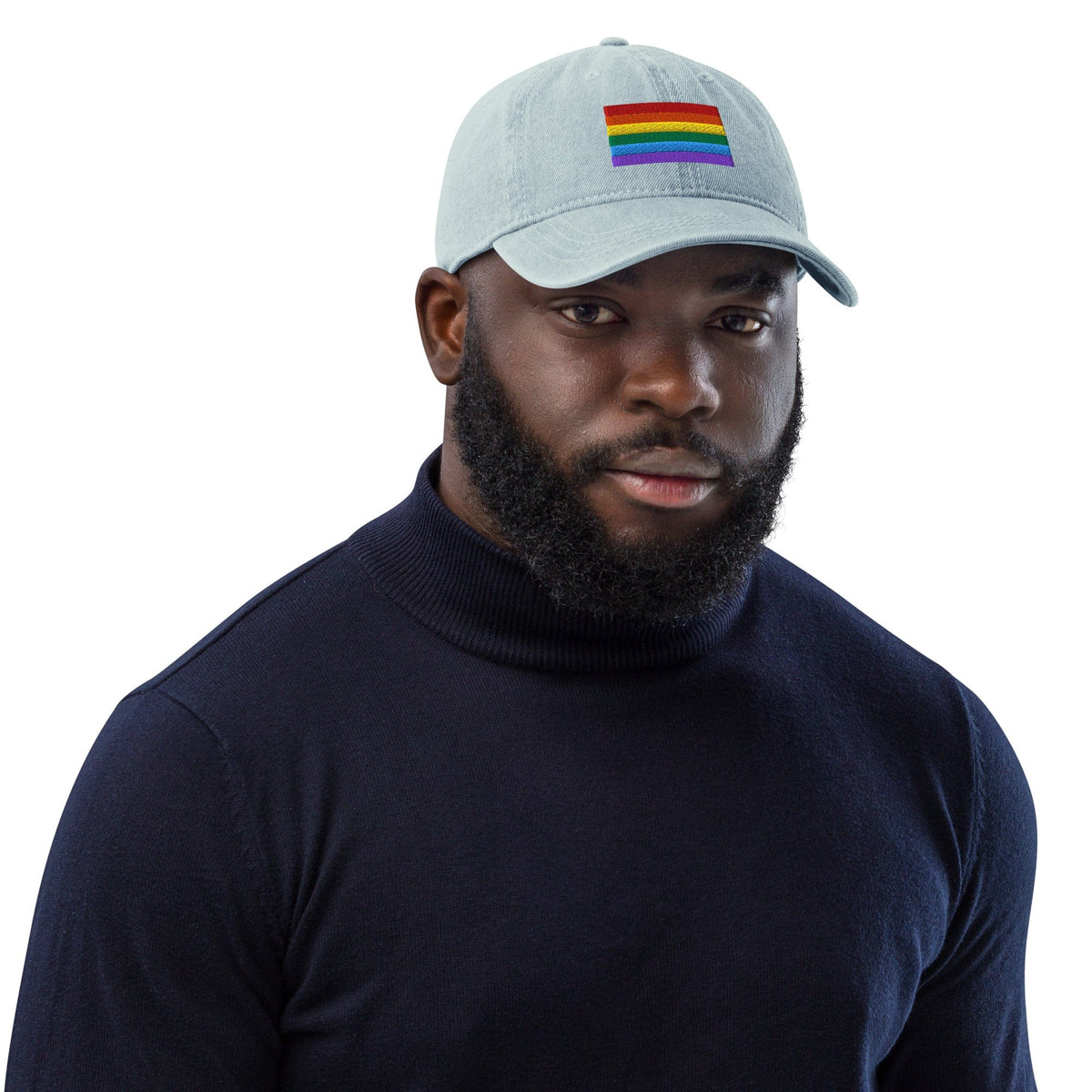 Light blue denim baseball cap with Pride rainbow flag embroidery, worn facing front