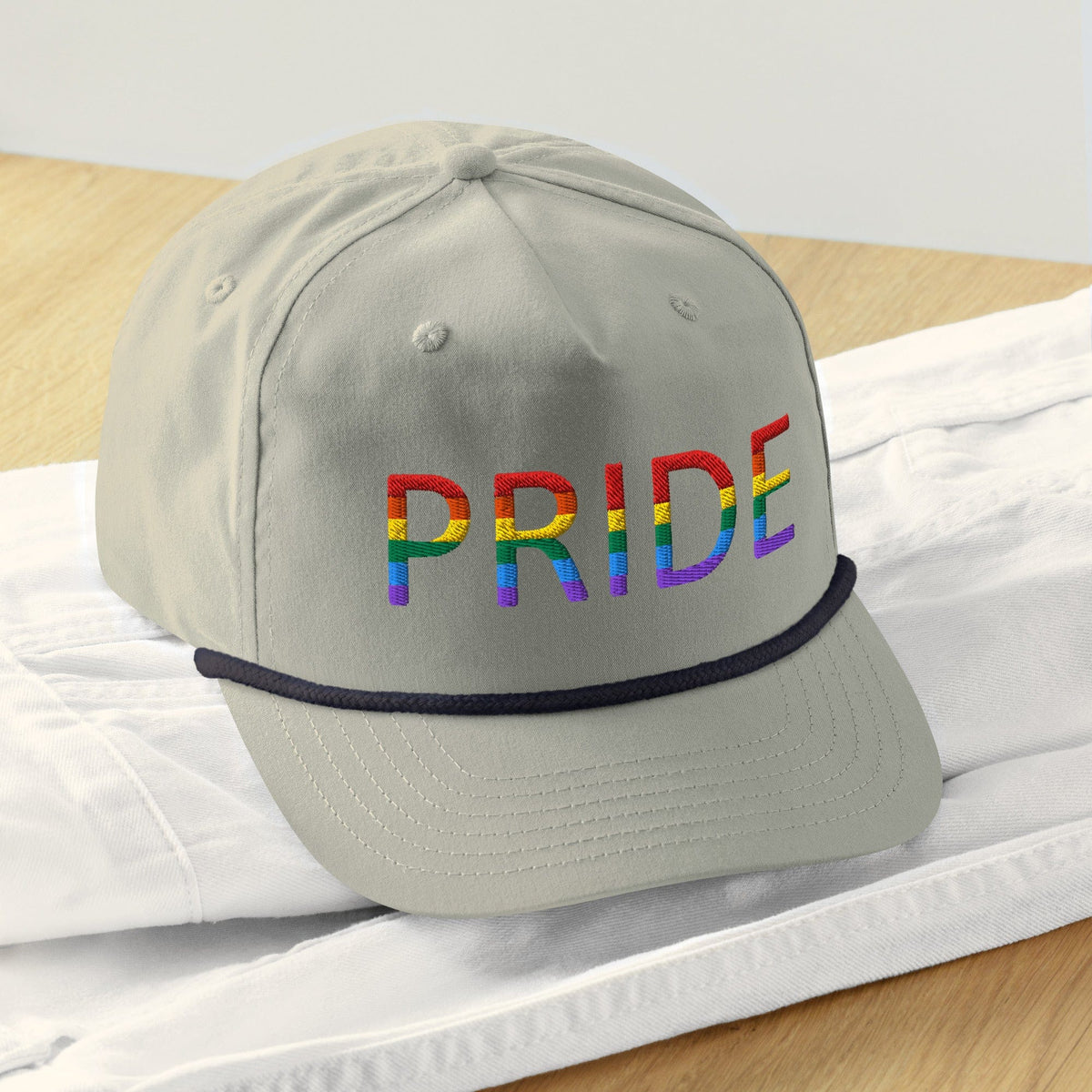 Light gray baseball cap with embroidered PRIDE logo and navy trim