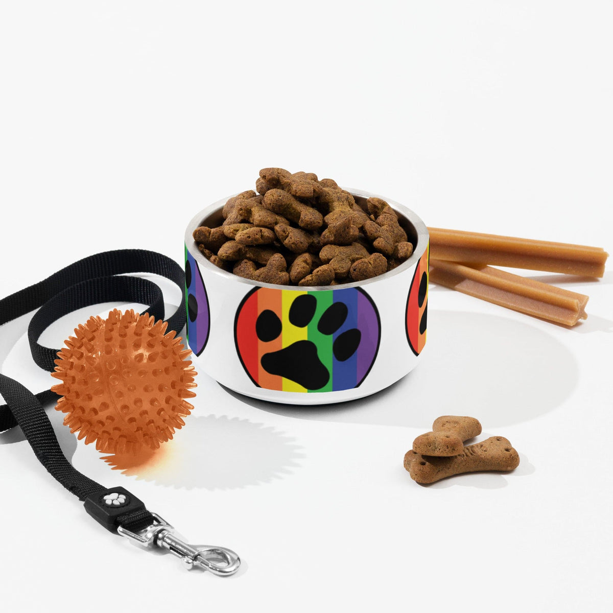 Rainbow paw print pet bowl filled with brown kibble, on a white surface
