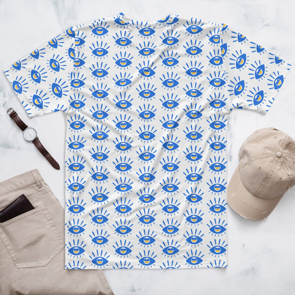 Men's t-shirt on flat surface with white fabric and blue eye pattern, crew neck, short sleeves