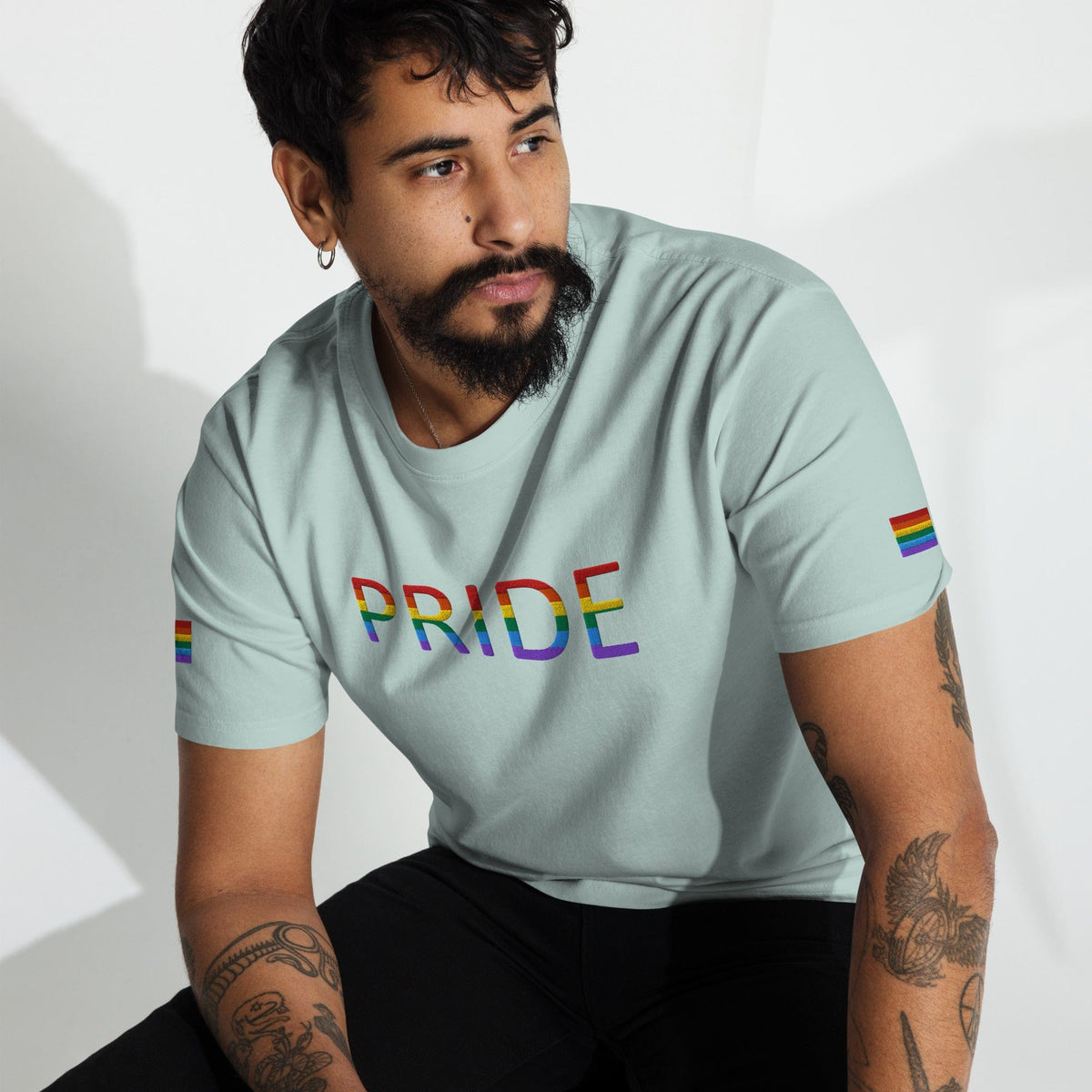 Light blue Pride graphic T-shirt with rainbow flag sleeve accents