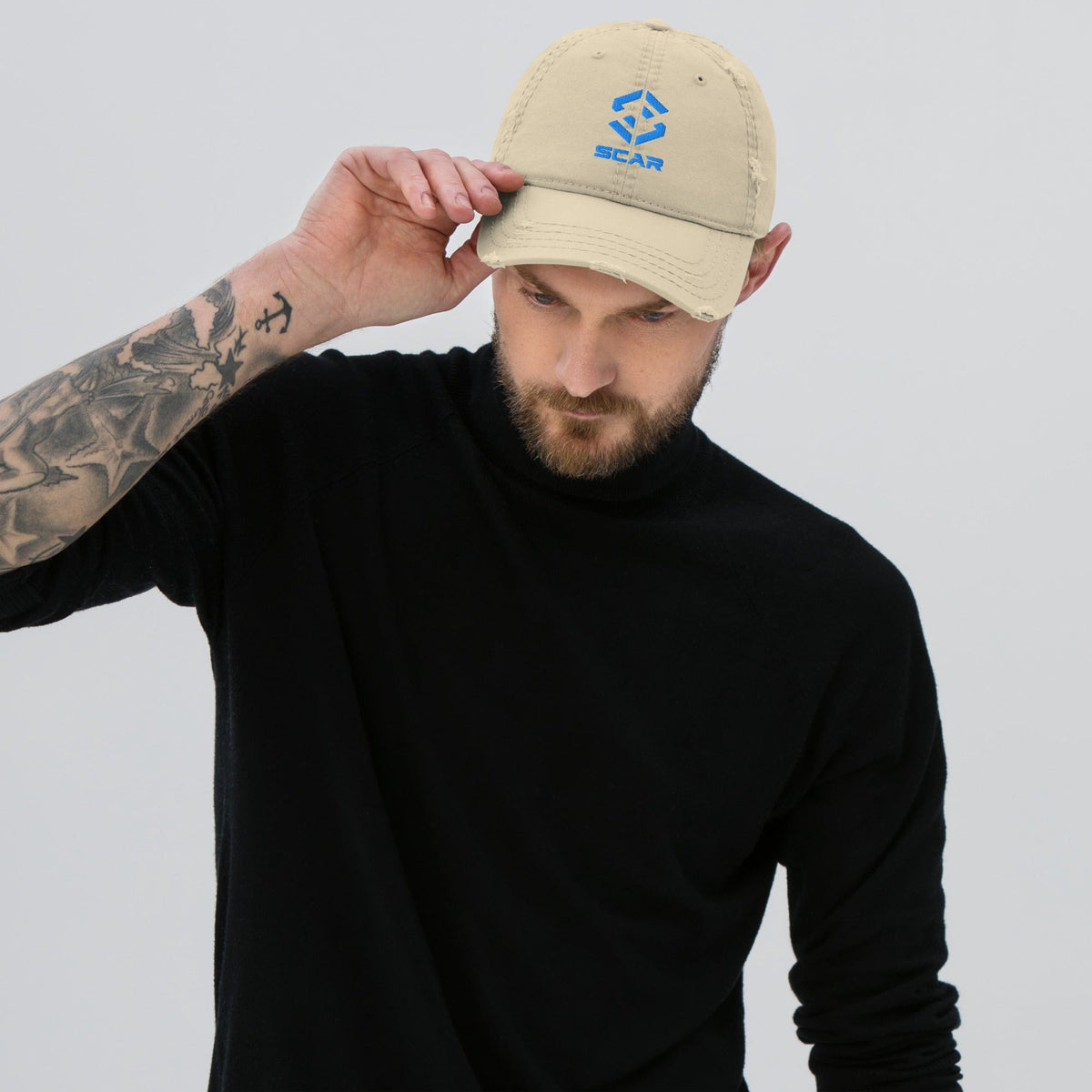 Distressed dad hat with embroidered SCAR logo, khaki, model wearing front-tilted view