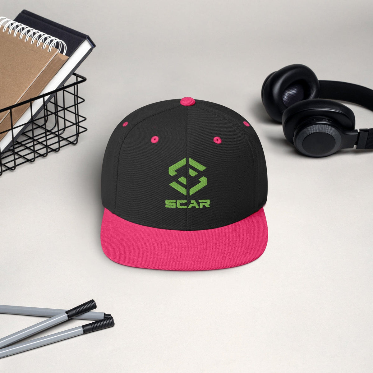 Snapback hat with embroidered SCAR logo, black crown with pink brim and pink eyelets.