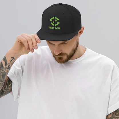 Black snapback hat with green SCAR logo embroidery and flat brim.
