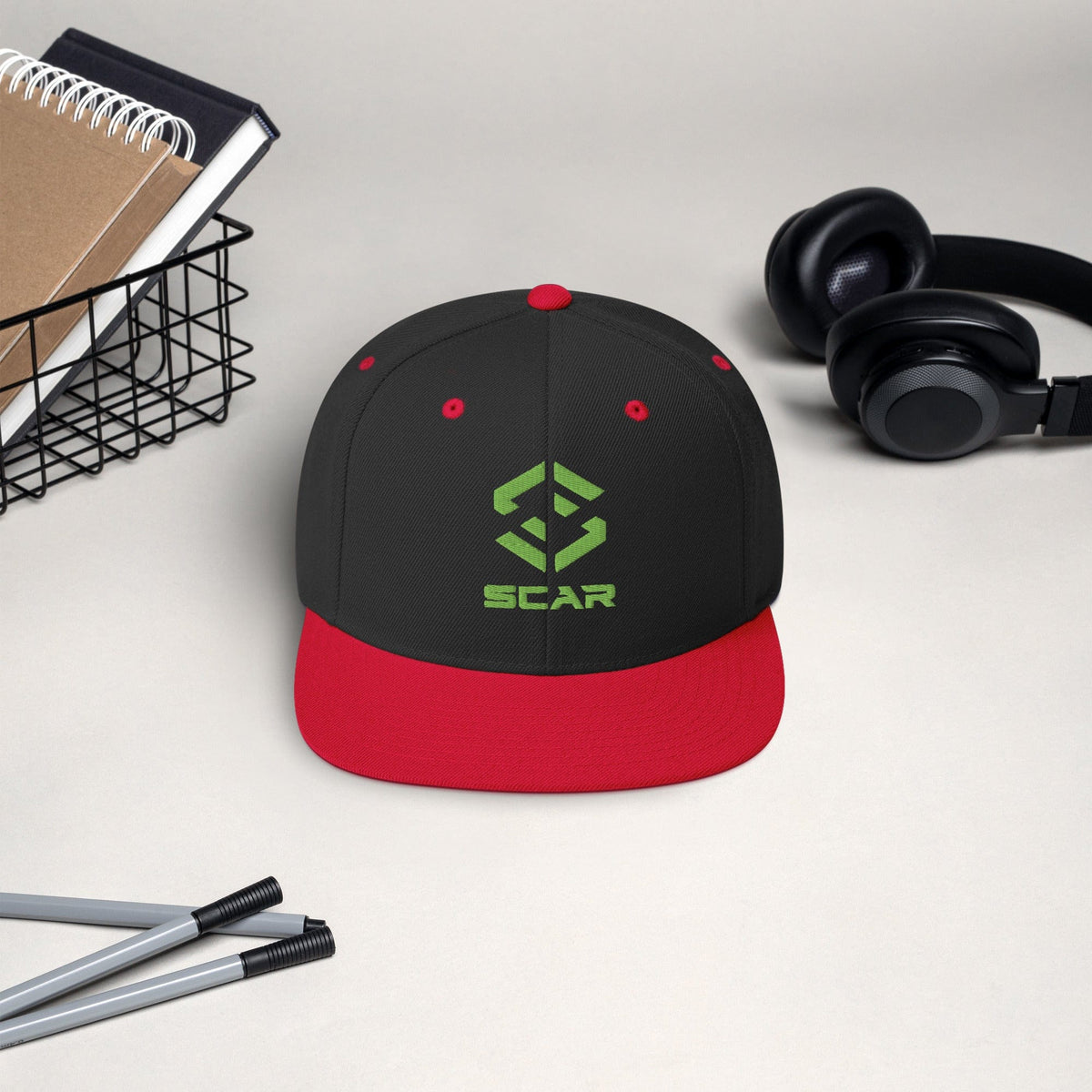 Snapback hat with embroidered SCAR logo, black crown with red brim and red eyelets.