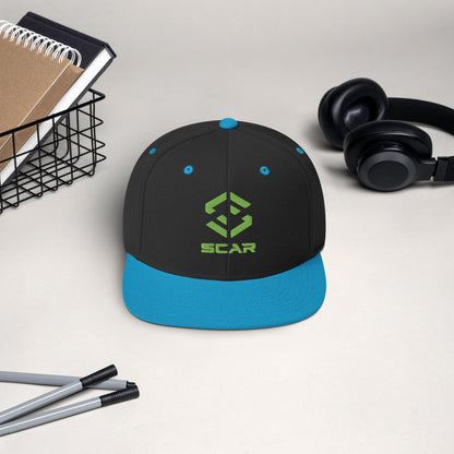 Snapback hat with embroidered SCAR logo, black crown and blue brim with blue eyelets.