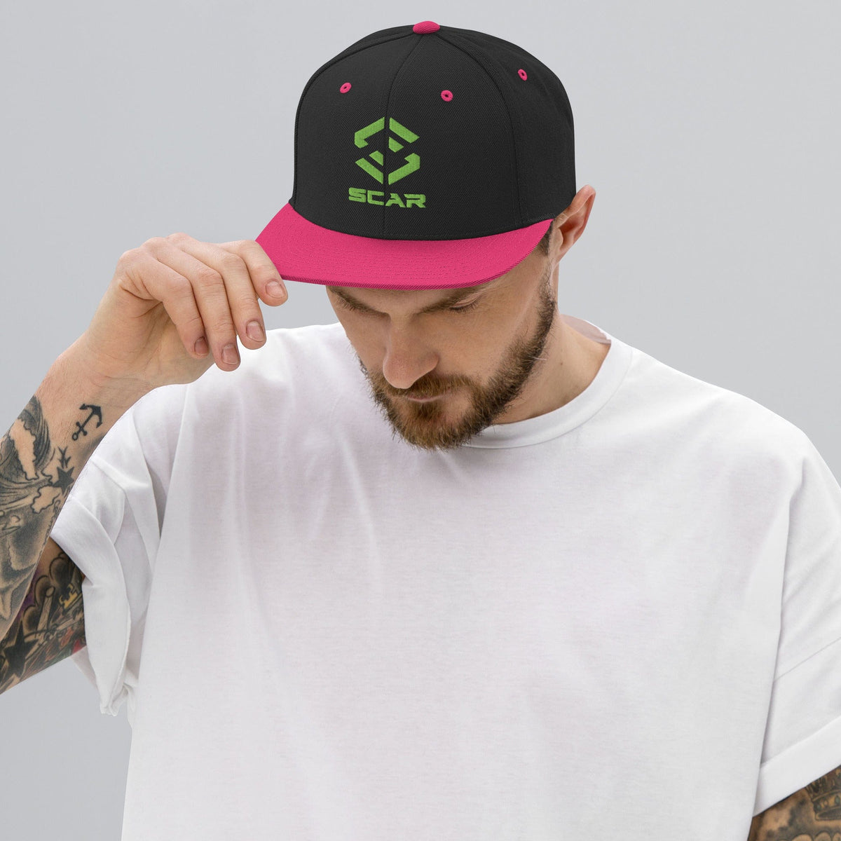 Snapback hat with embroidered SCAR logo, black crown and neon pink brim.