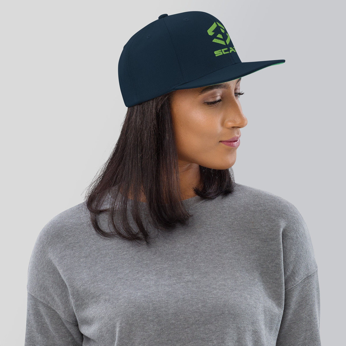 Dark navy snapback hat with green SCAR logo embroidery and flat brim.