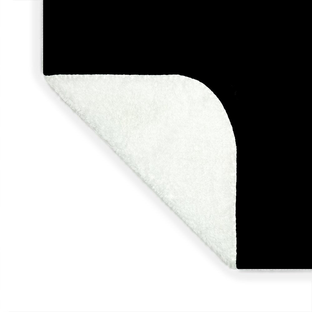 Dark blanket corner showing off-white sherpa underside along curved edge