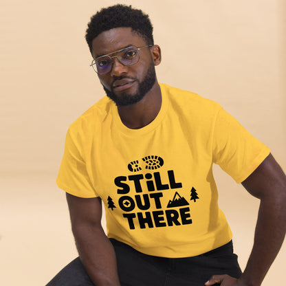Yellow hiking T-shirt with black “Still Out There” logo graphic and paw-tree icon