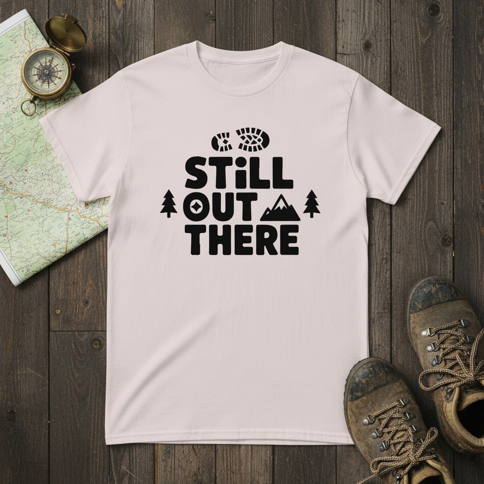 Light pink hiking T-shirt with black 'Still Out There' logo and tree graphic