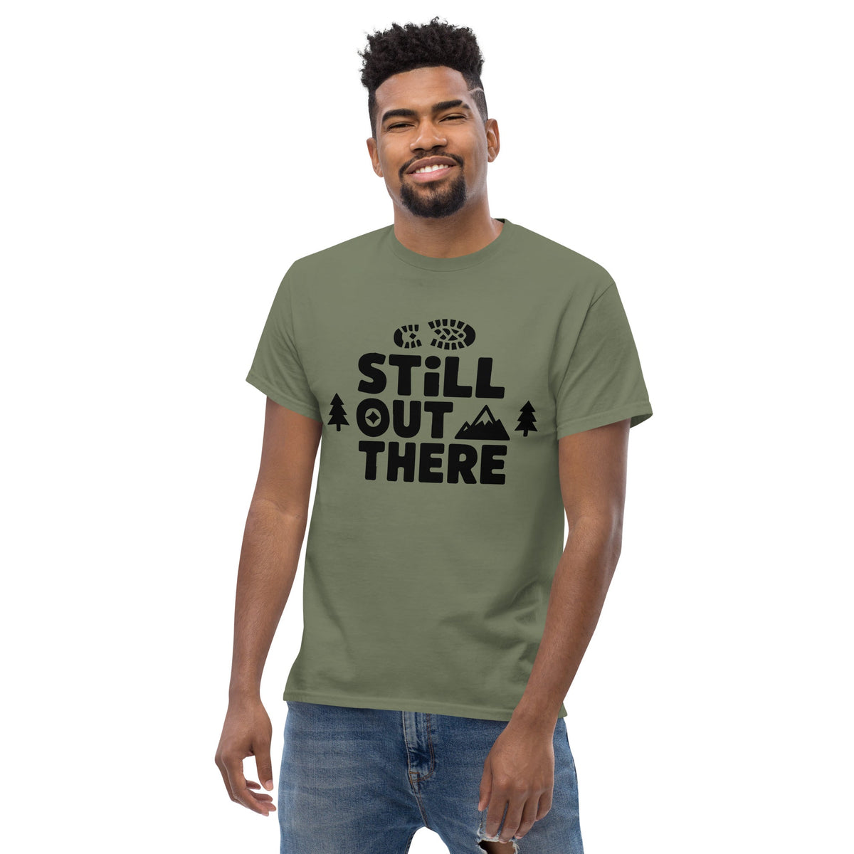 Dark green hiking T-shirt with black “Still Out There” logo graphic and paw-tree icon