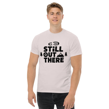 Light pink hiking T-shirt with black “Still Out There” logo graphic and paw-tree icon