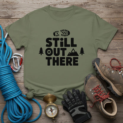 Olive green hiking T-shirt with black 'Still Out There' logo and tree graphic