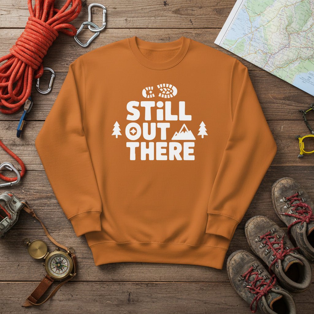 Brown hiking sweatshirt with crew neck and white “Still Out There” logo