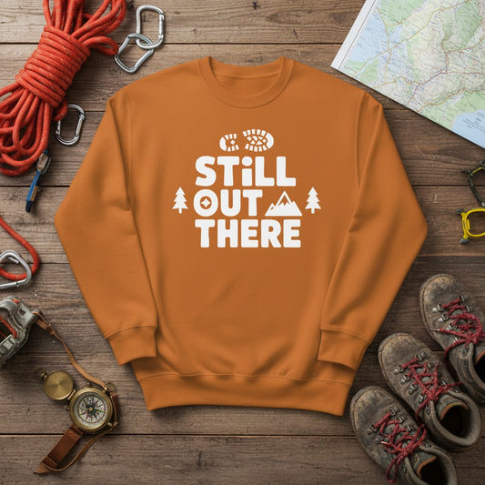 Brown hiking sweatshirt with crew neck and white “Still Out There” logo