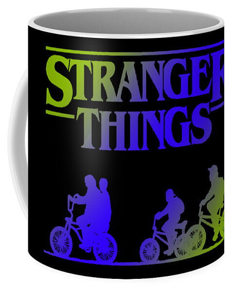 Black ceramic mug with Stranger Things logo and character silhouettes in green, purple, blue.