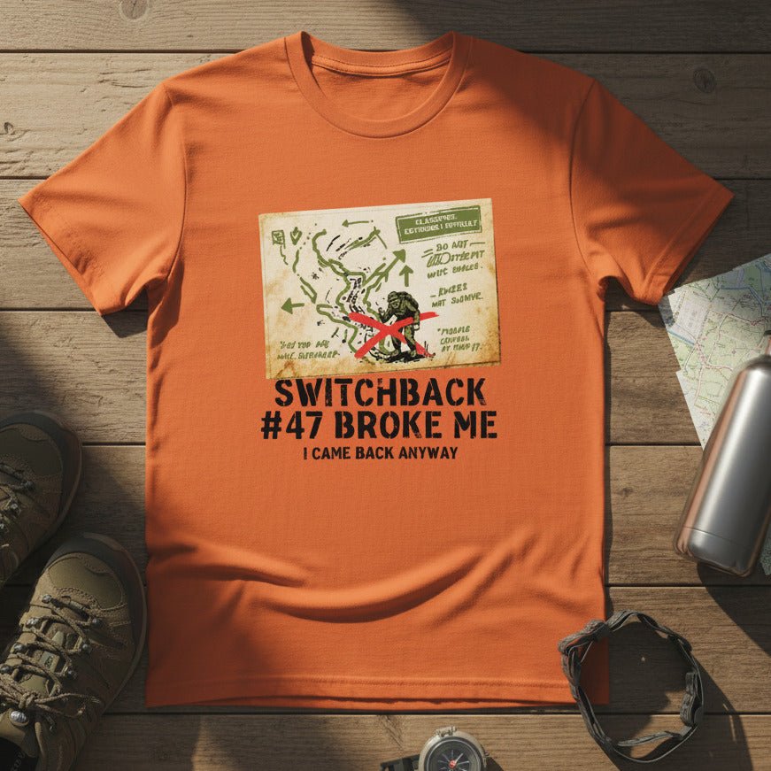 Orange hiking T-shirt with front map-style graphic and “Switchback #47 Broke Me”