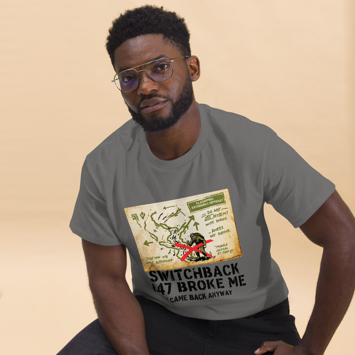 Gray hiking t-shirt with printed map graphic and red figure on the front, worn